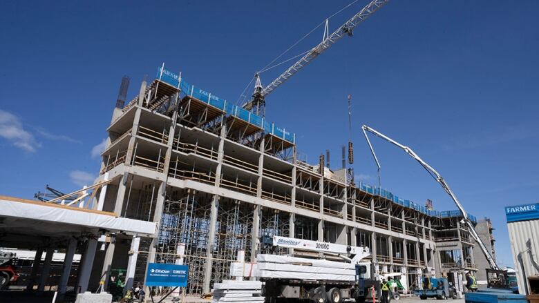 Cranes and workers at a building under construction in Victoria. 