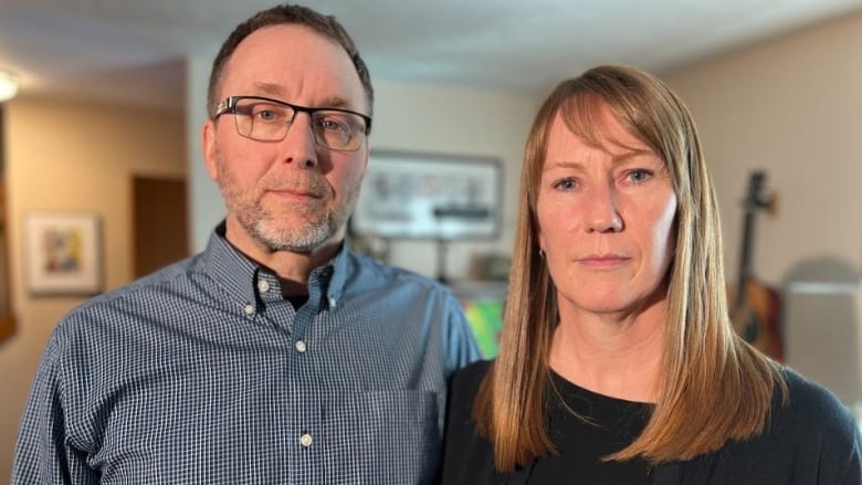 A man and a woman stand beside each other in a home.