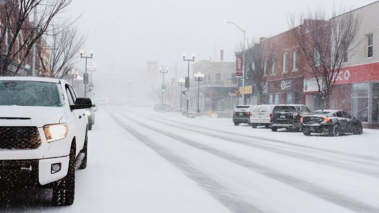 A white truck is parked on a snow covered downtown street in Kenora, Ont.