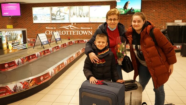 A grandmother, daughter and grandson pose for a photo at the Charlottetown airport. 