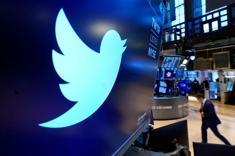 The Twitter logo is displayed on a large screen at a stock exchange. 