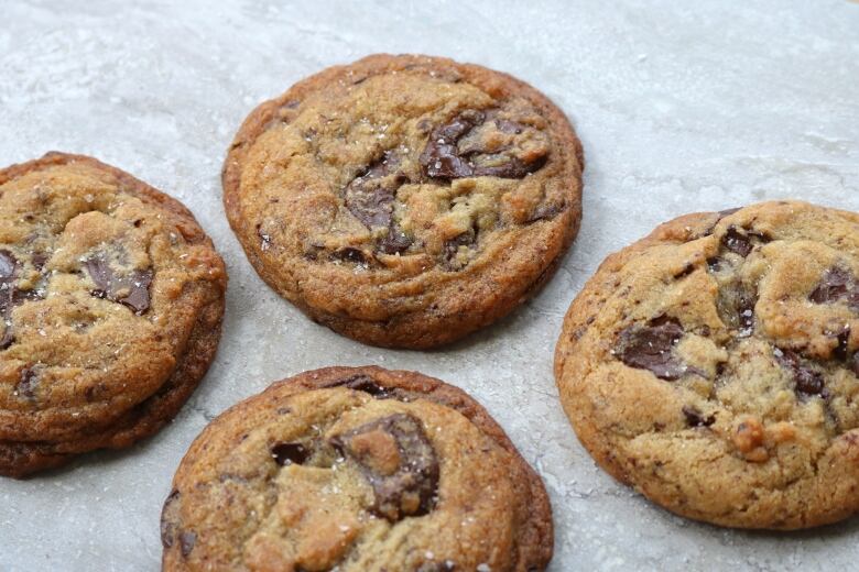 Four chocolate chunk cookies sit on a tray