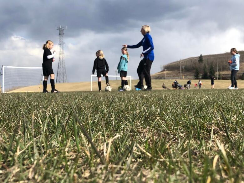 Kids on field playing with soccer ball.