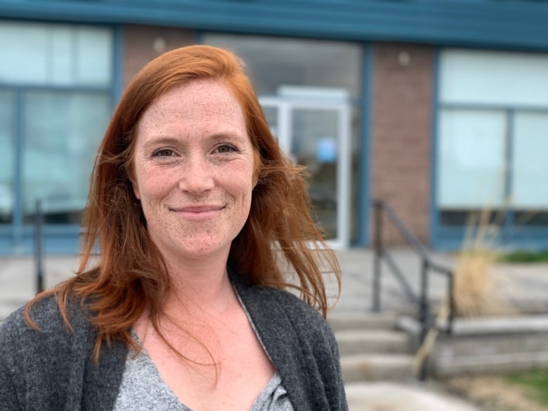 A political candidate smiles for a photo outside an office in spring.