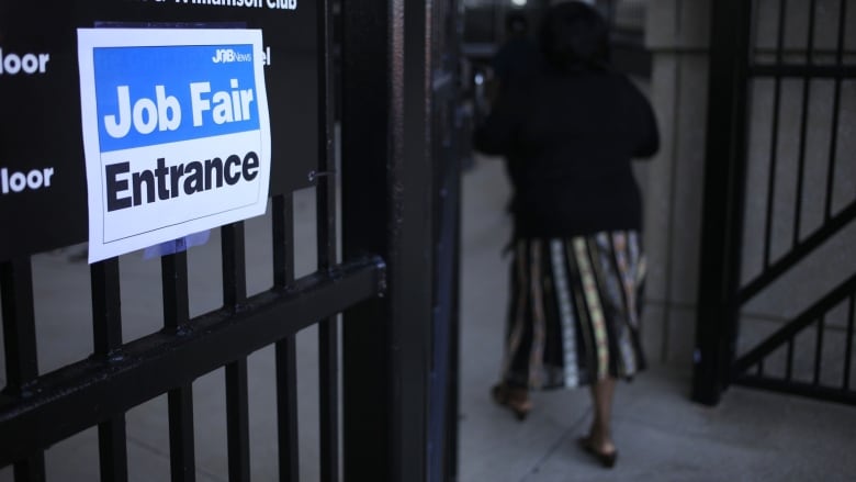 A sign advertising a job fair is shown on a window