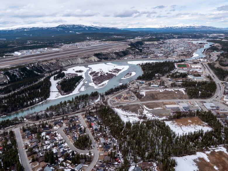 An aerial shot of a small city and a river.