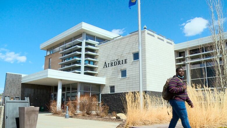 A person walks by a city hall building.