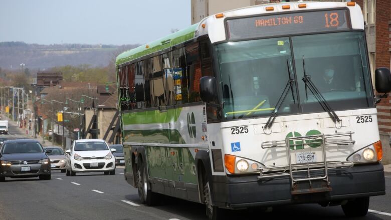 A GO Transit bus along a busy street.