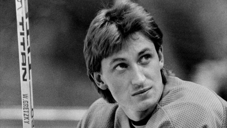 A black and white photo of a young Gretzky in an Oilers Jersey. 