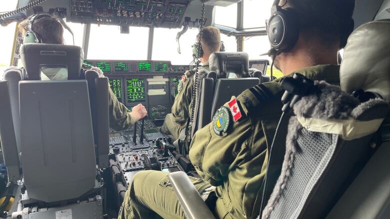 Canadian pilots at the controls of a C-130J flying over Europe, airlifting aid for Ukraine.