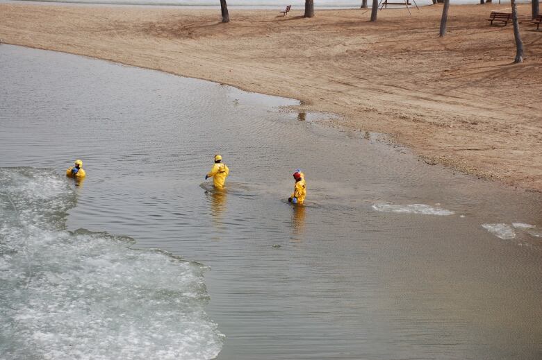 A team of people in yellow gear work on a water rescue.