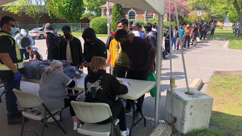 A line of people wait to get food at a UHC - Hub of Opportunities food bank at Adie Knox on Thursday.