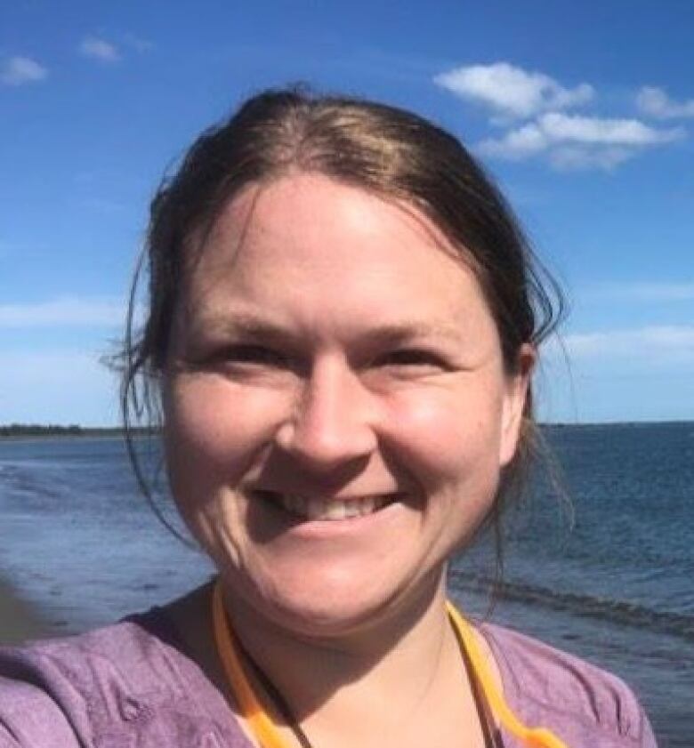 A selfie of a woman standing on the beach