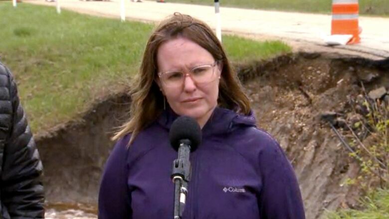 A woman standing by a microphone.