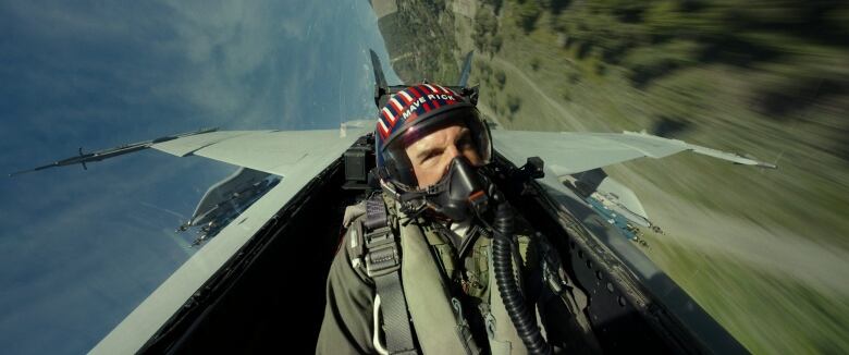 A male actor wearing a pilot's helmet is shown flying in a hypersonic fighter airplane.