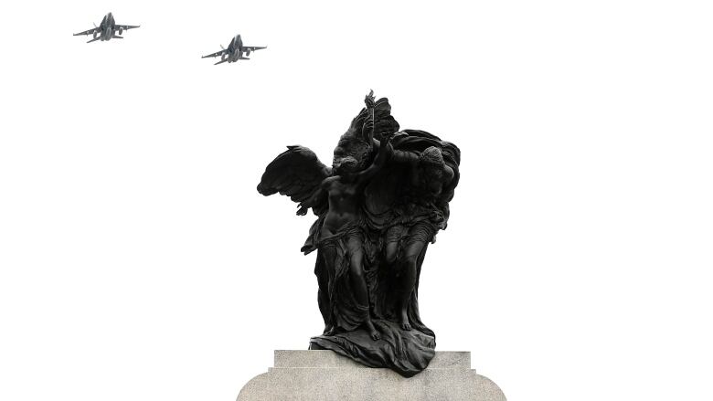 Royal Canadian Air Force CF-18 Hornets pass the top of the National War Memorial during a D-Day commemoration in Ottawa Monday, June 6, 2022.