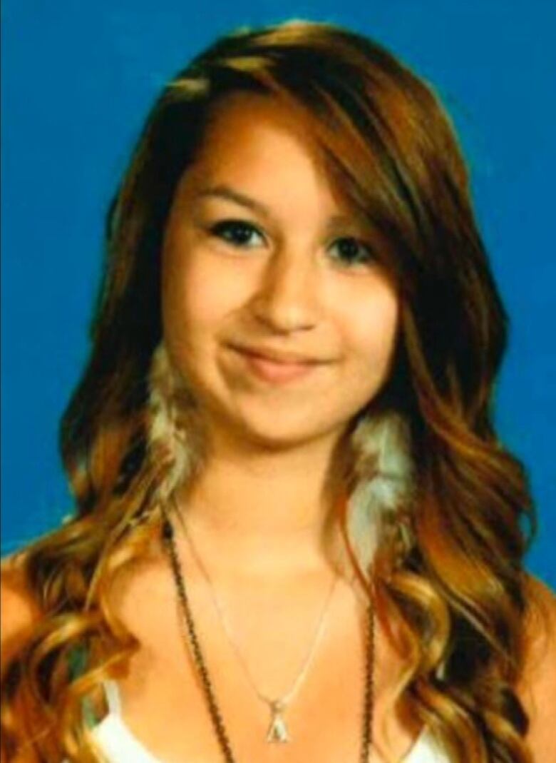 Amanda Todd smiles for a picture. She is wearing a white top.