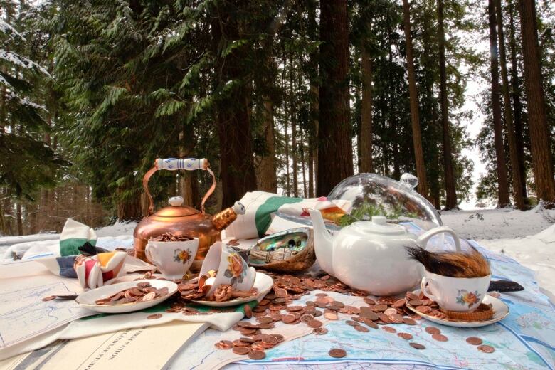 Still life photograph of objects arranged on maps and HBC napkins, shot in the woods.