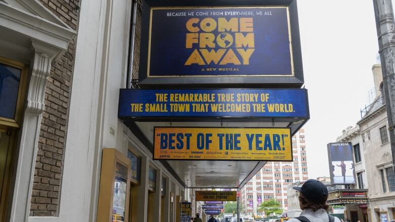 The marquee of the Broadway musical Come From Away above a New York sidewalk.