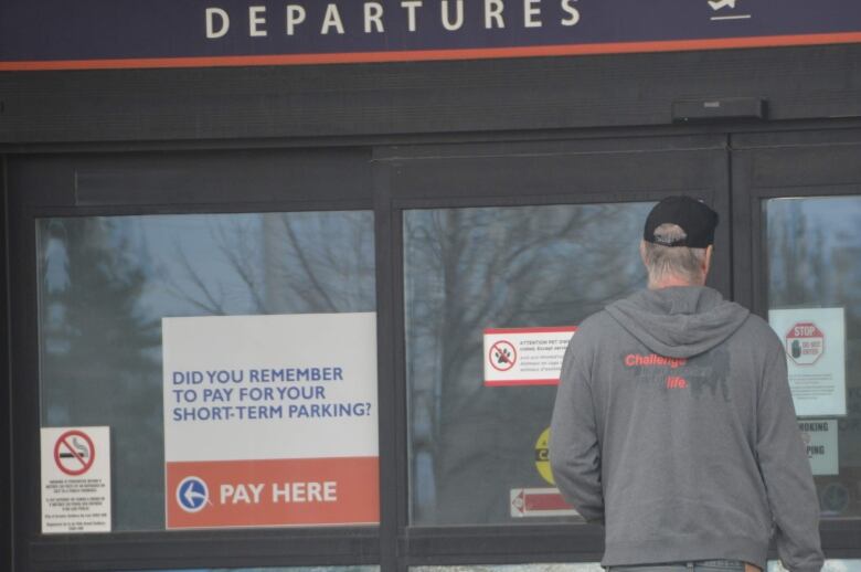 man with suitcase entering Greater Sudbury airport