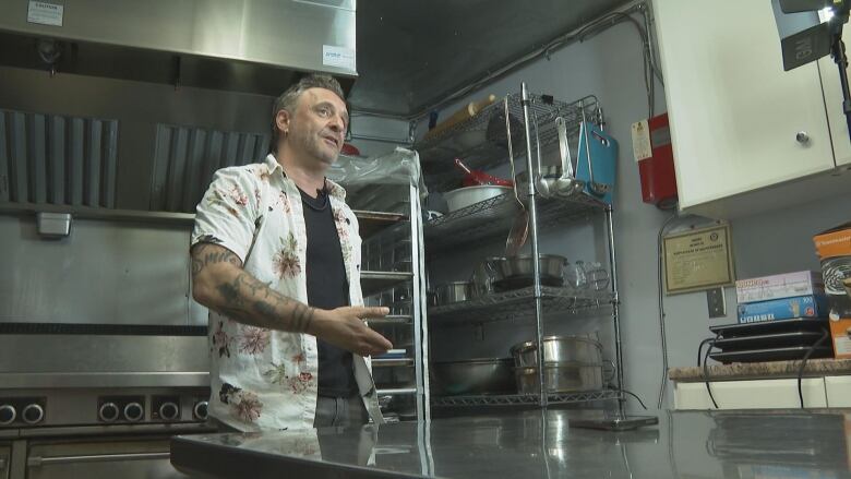 Jody Williams, heavily tattooed and wearing a relaxed Hawaiian shirt, gestures and stands in the empty industrial kitchen of Bridges to Hope.