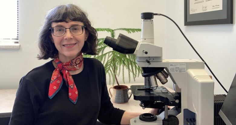 Pathologist Dr. Laurette Geldenhuys is pictured with a microscope.