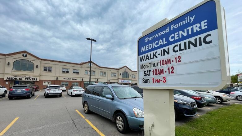 Sign outside a medical clinic listing its hours of operation. 