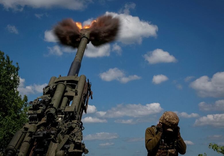 Ukrainian service members fire a shell from a M777 Howitzer near a frontline