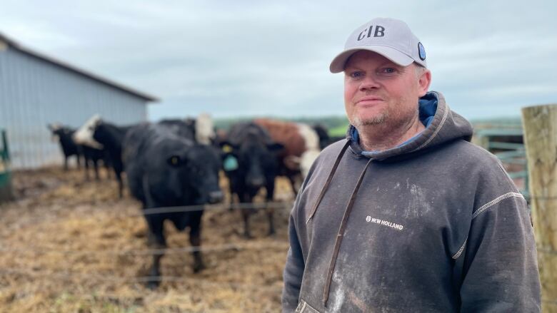 Farmer stands in front of beef cattle