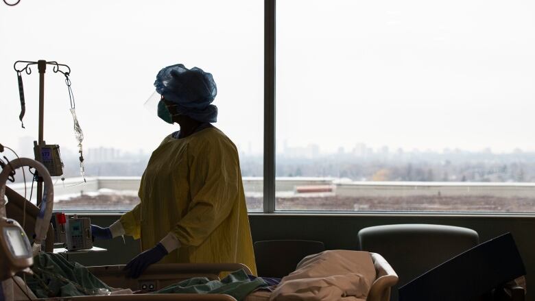 A nurse works in a hospital room.