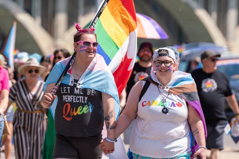 Two people hold hands at the Saskatoon Pride parade.