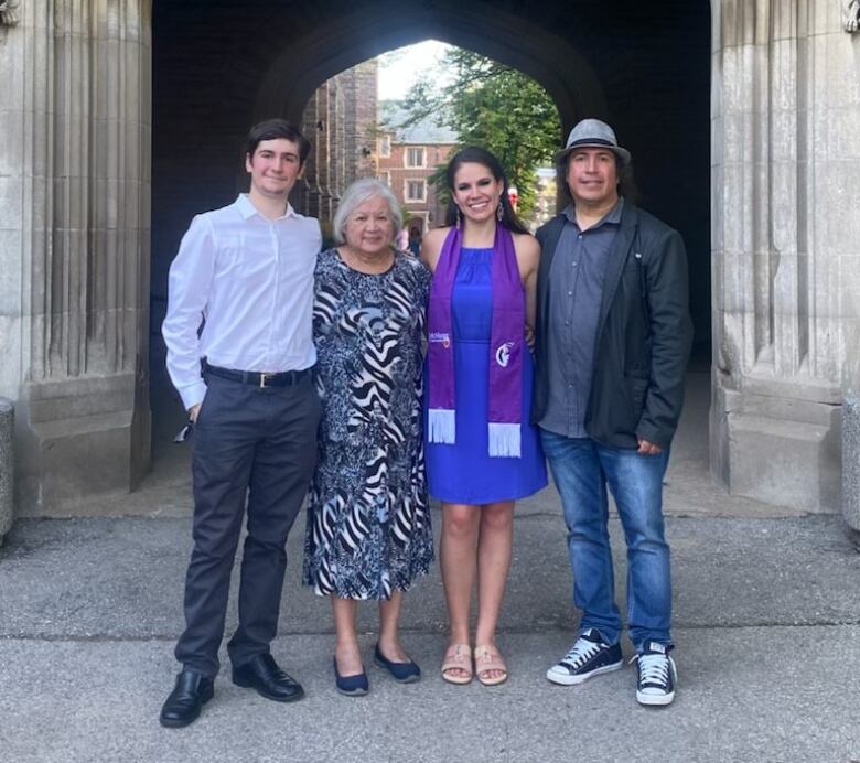 Four people stand side-by-side.