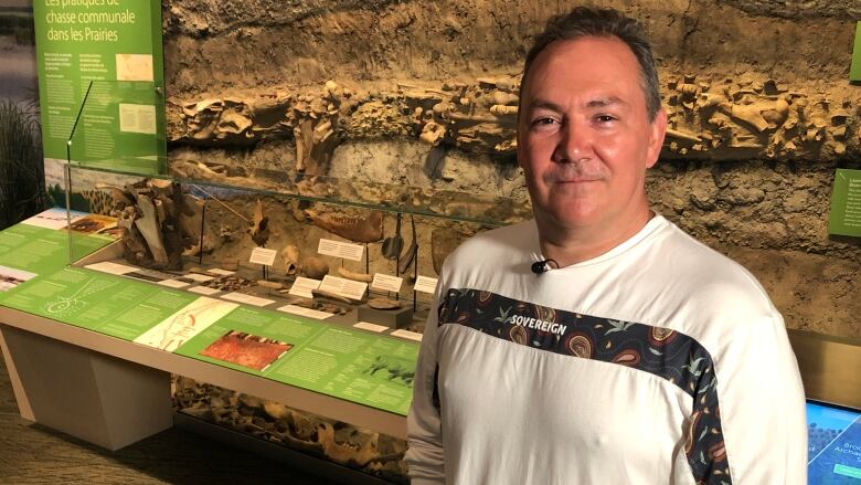 Kevin Brownlee stands in front of a museum display. 