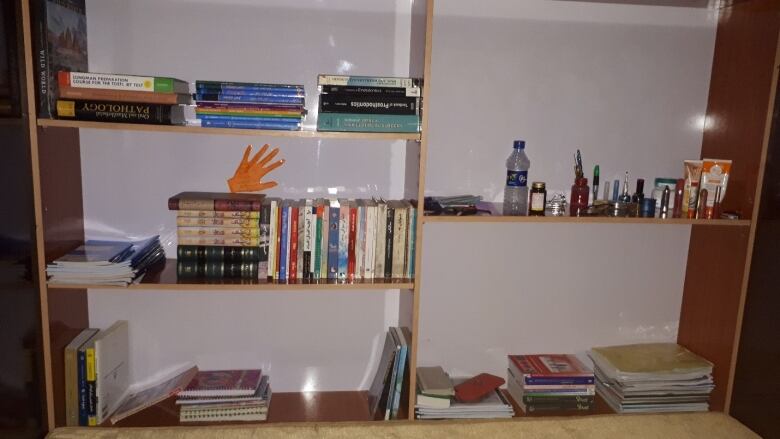 A shelf filled with books and personal items.