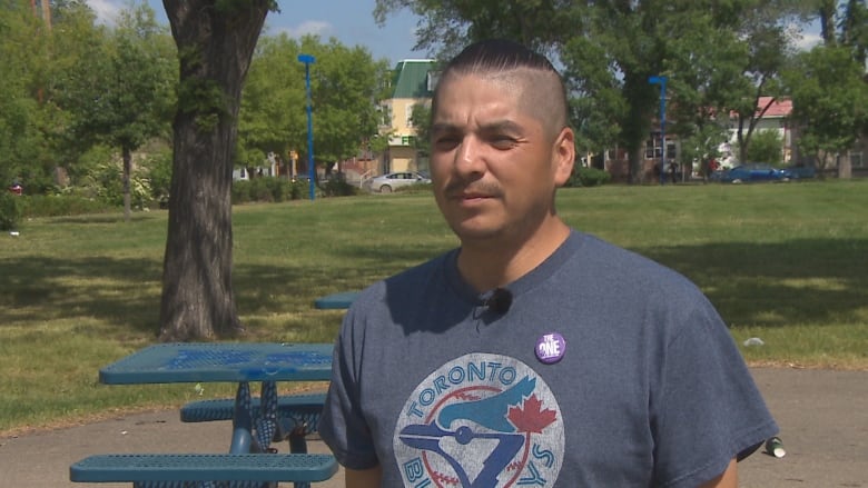 A man in stands in a park in a Toronto Blue Jays t-shirt