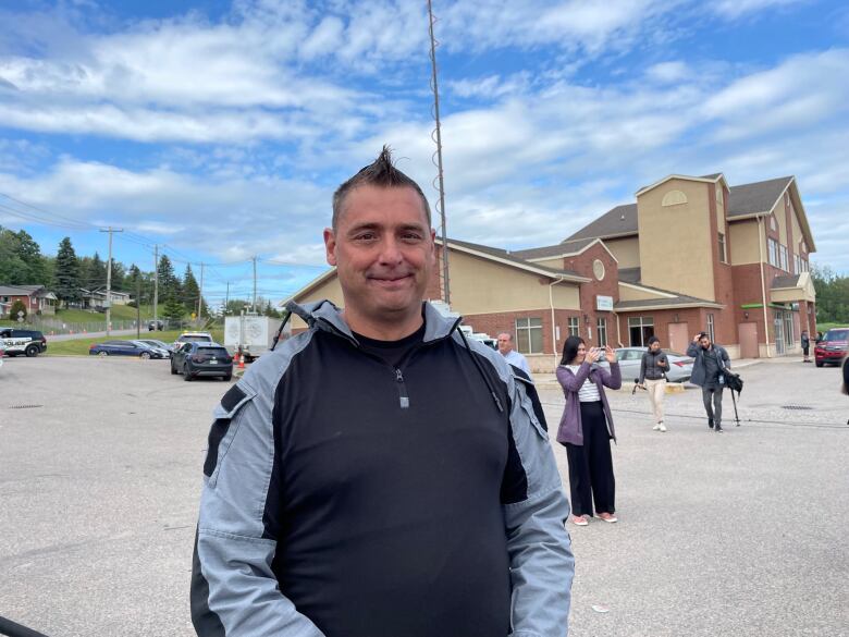 Man stands in parking lot.