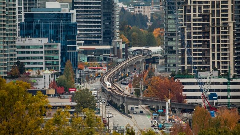 A SkyTrain is pictured travelling through the new towers of the Brentwood neighbourhood in Burnaby during fall.