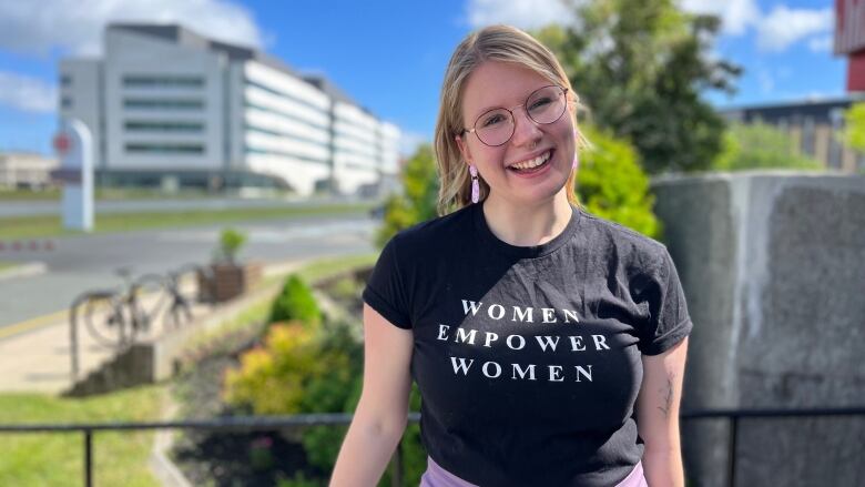 A woman standing outside on a sunny day.