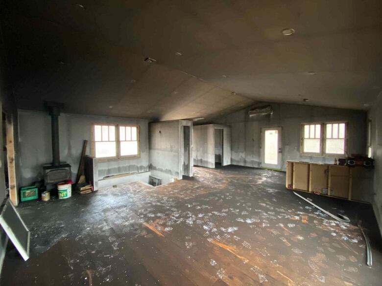 A vacant room with grey walls and grey floors.