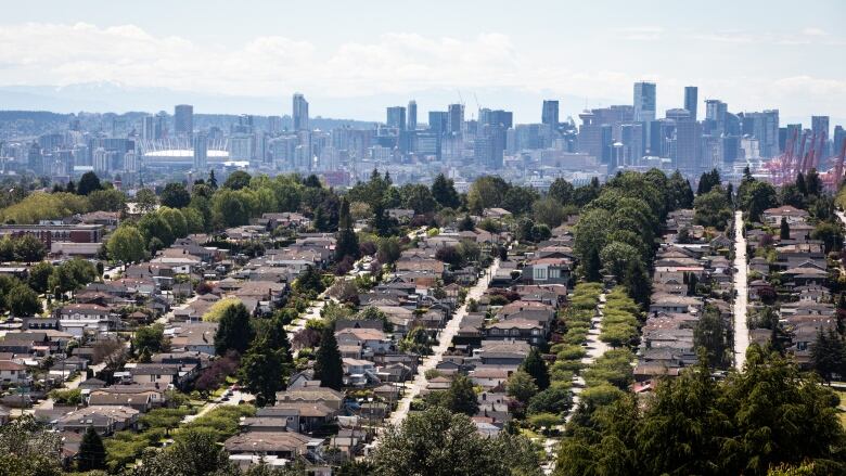 Rows of single-family homes are pictured in the foreground of the Vancouver skyline.