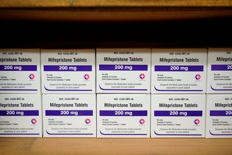 Boxes of pills are seen stacked on a shelf.