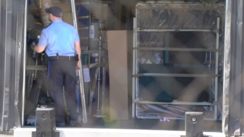 A police officer is seen inside a warehouse.