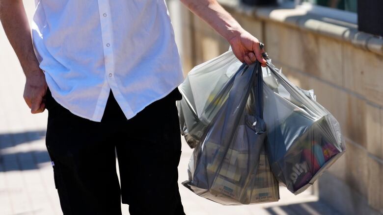 Someone carrying three or four plastic shopping bags in one hand.