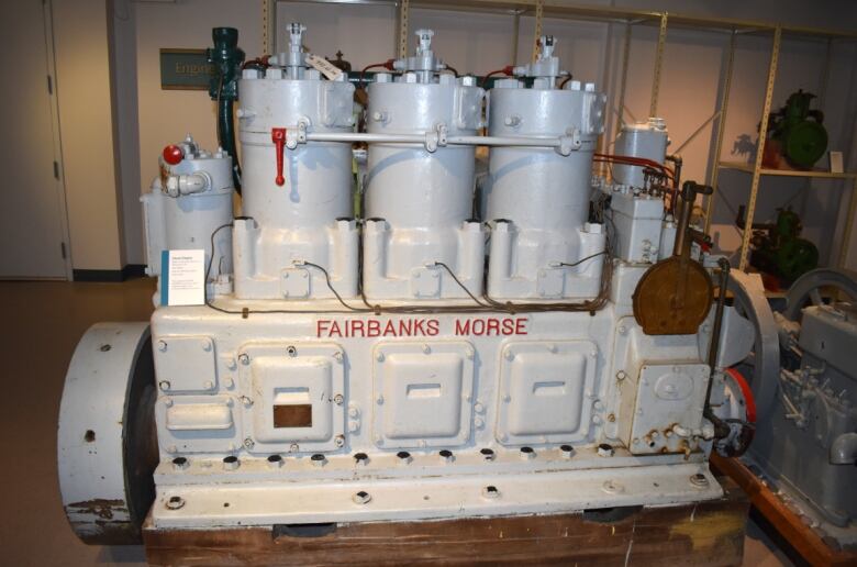 A large grey ship's engine is displayed at a museum.