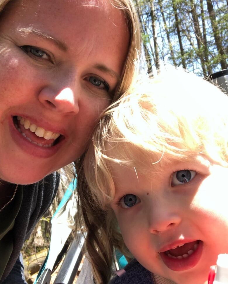 A woman and her young son with blonde hair pose for a close-up selfie.