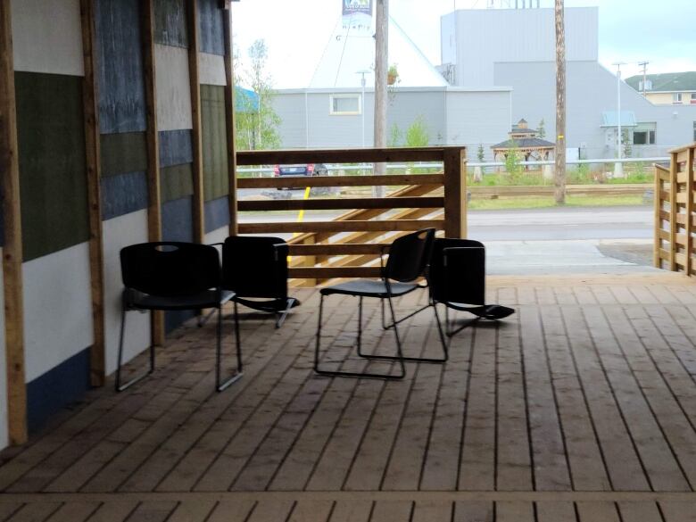 Chairs, some knocked over, outside of a building.