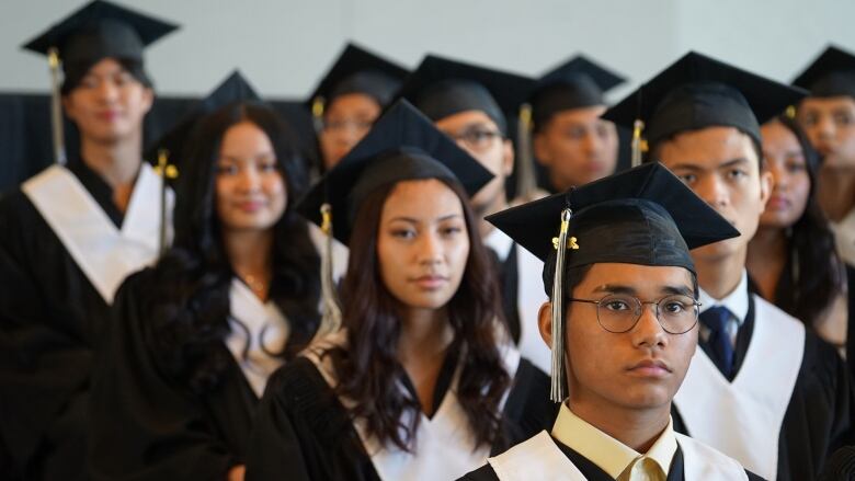 Students standing at a graduation ceremony