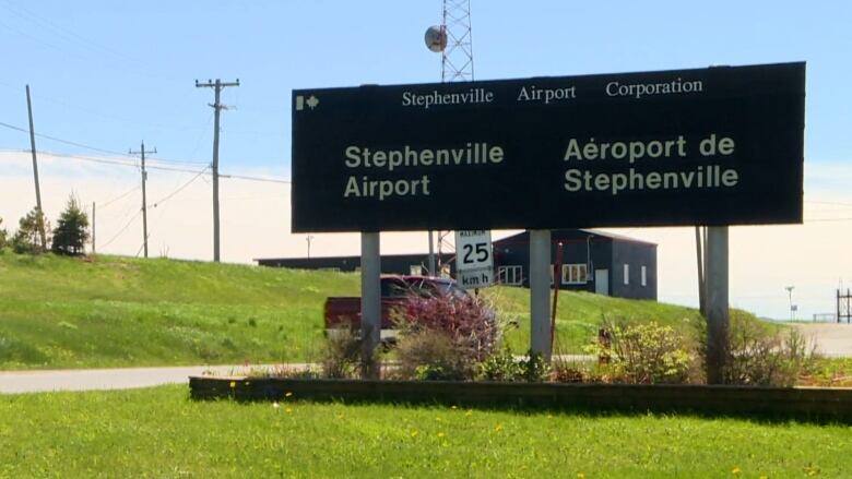 A sign saying Stephenville Airport sits on green grass.