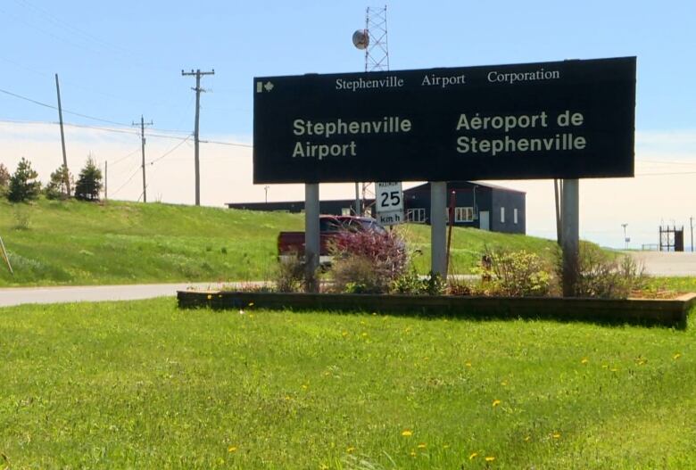 A sign saying Stephenville Airport sits on green grass.