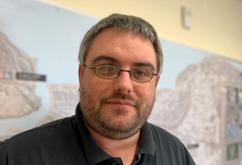 Headshot of man standing in front of map of Rimouski.